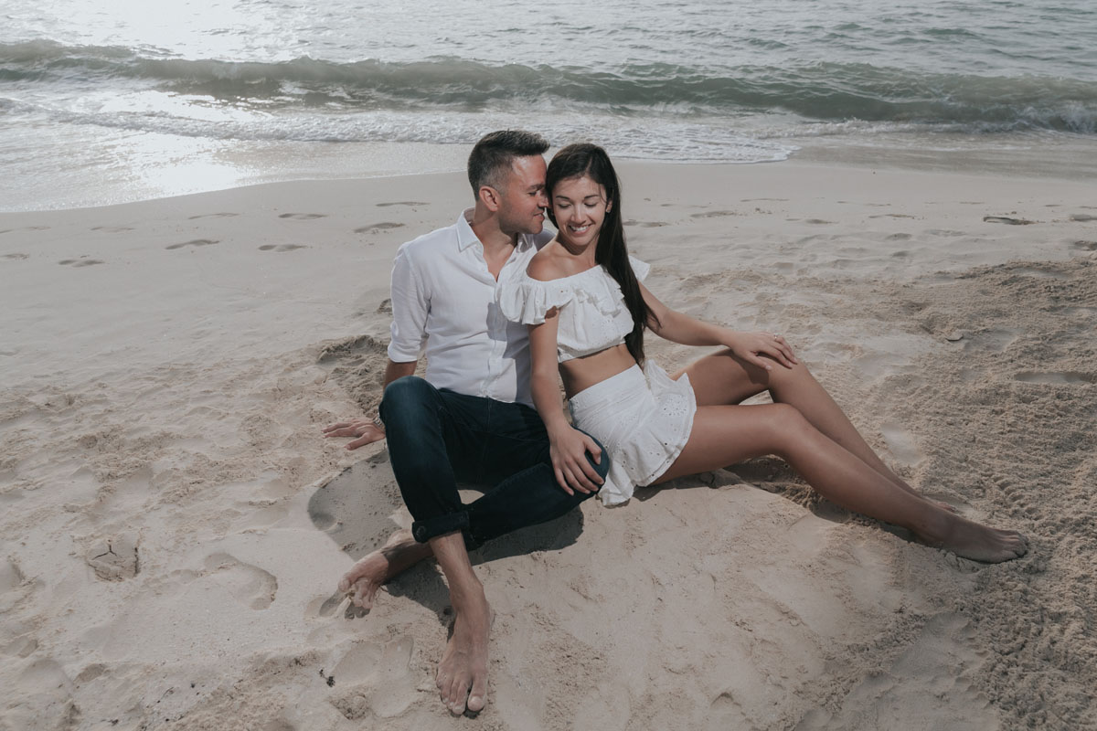 NewlyEngagedCoupleSnuggleOnBeach