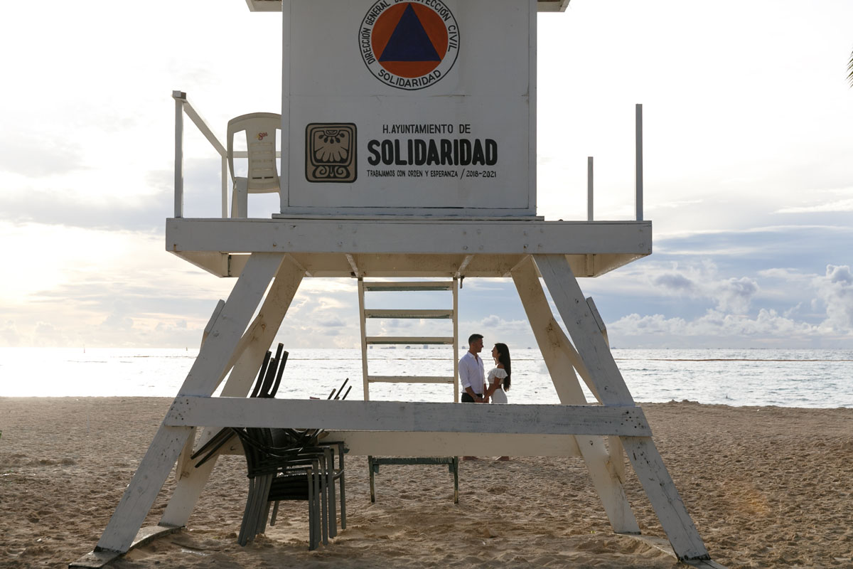 NewlyEngagedCoupleByLifeGuardTowerOnBeach