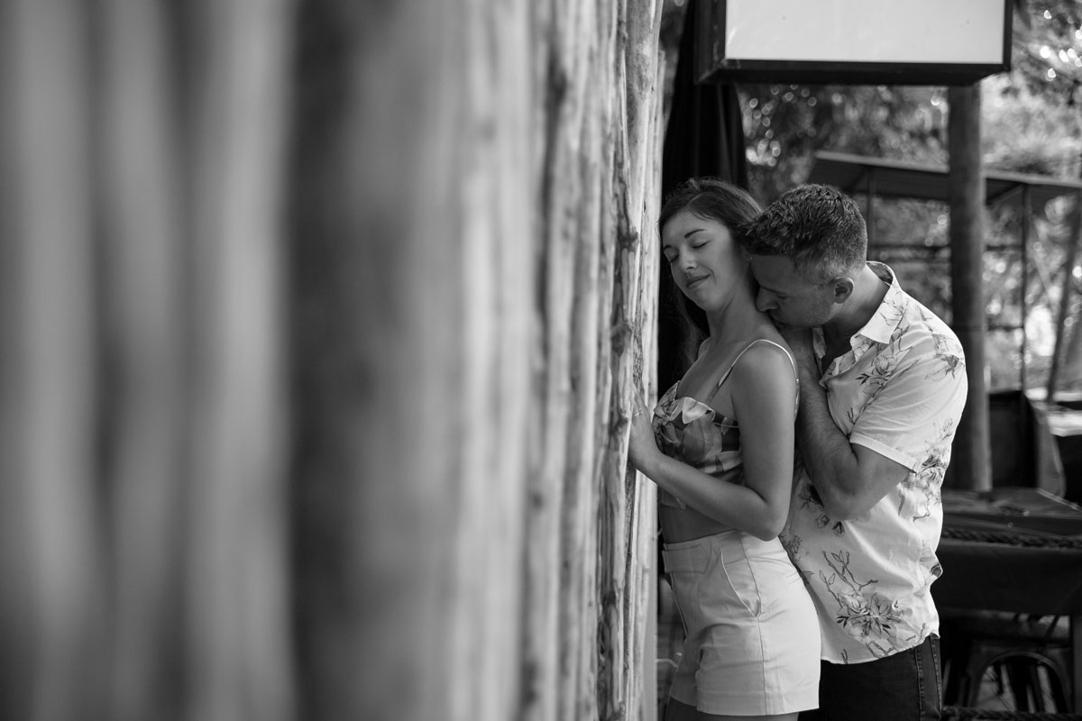 NewlyEngagedCoupleEmbraceByReedWall