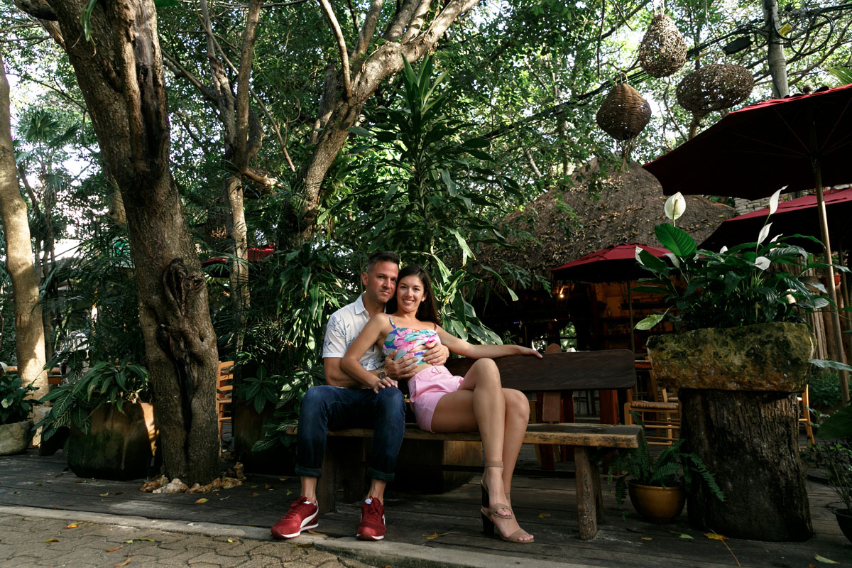 NewlyEngagedCoupleSitOnWoodenBench