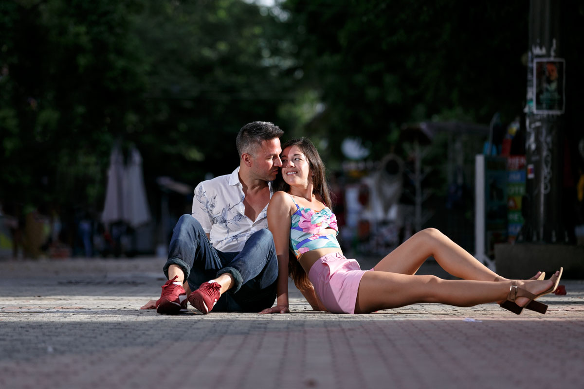 NewlyEngagedCoupleSitOnCitySidewalk