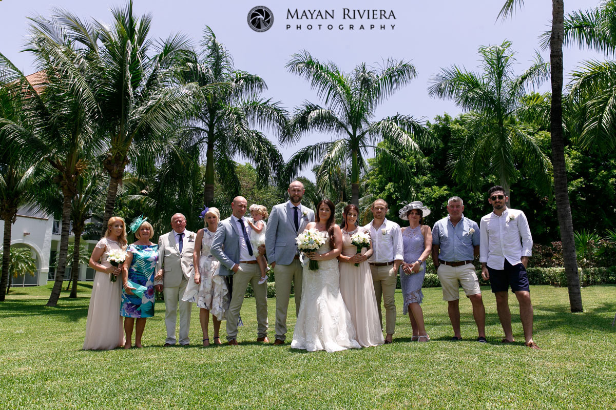 NewlywedsAndGuestsPoseOnLawn