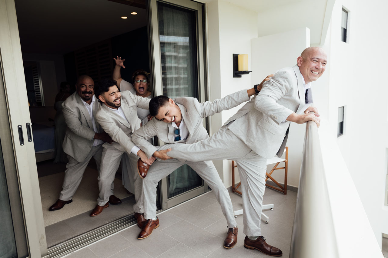 Groomsmen Holding Back Groom From Jumping Over the Balcony