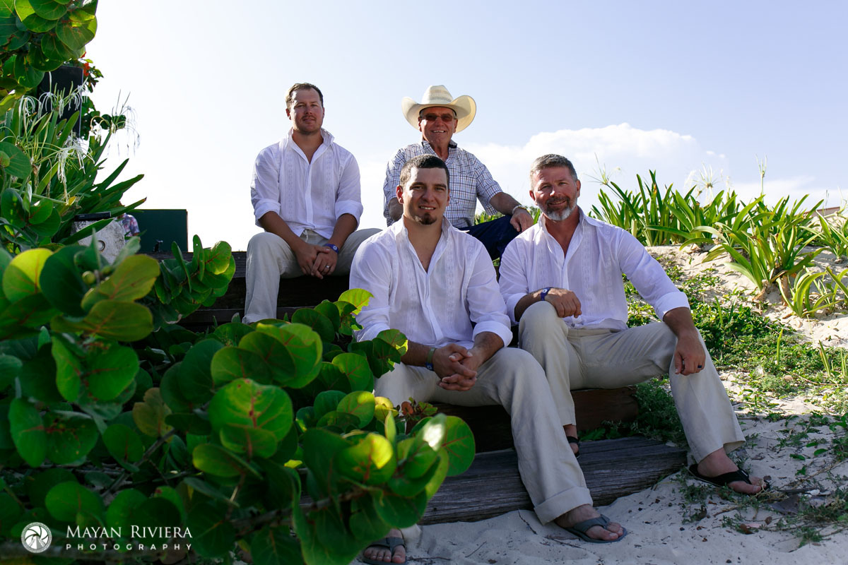 GroomAndBuddiesSittingOnBeachSteps
