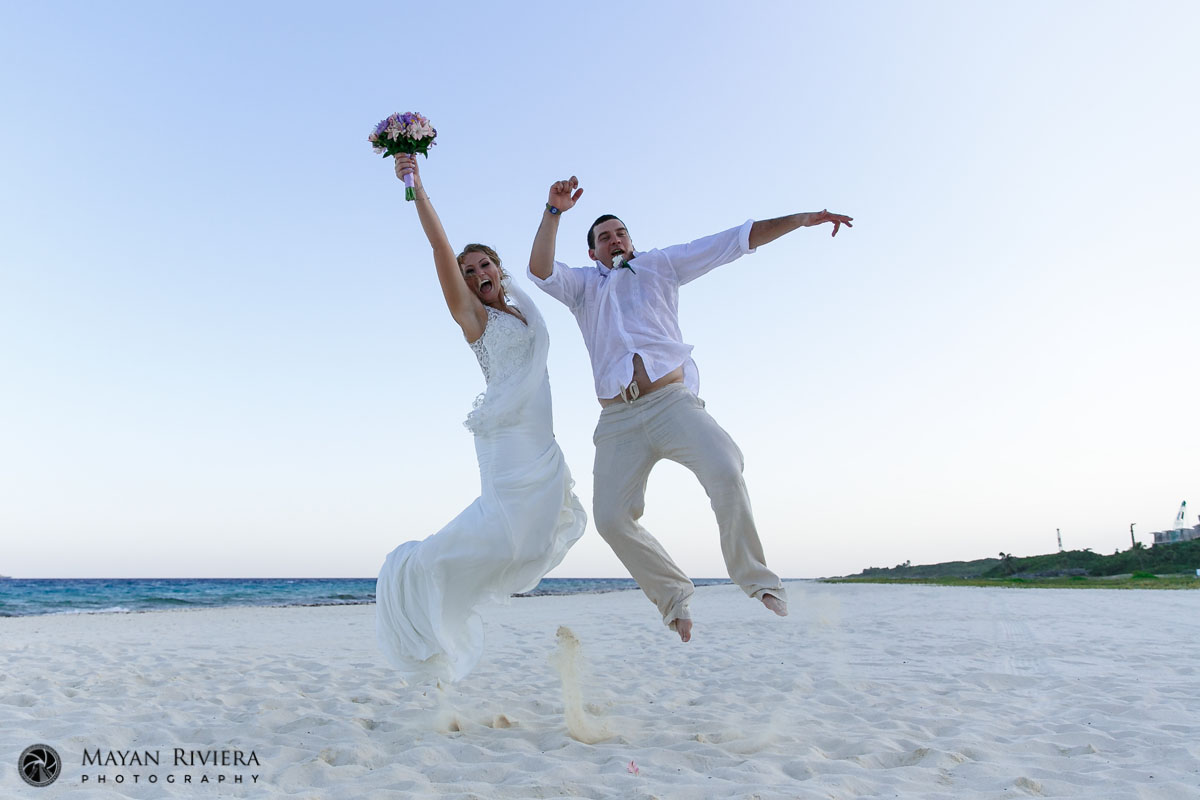 NewlywedsJumpingOnBeach