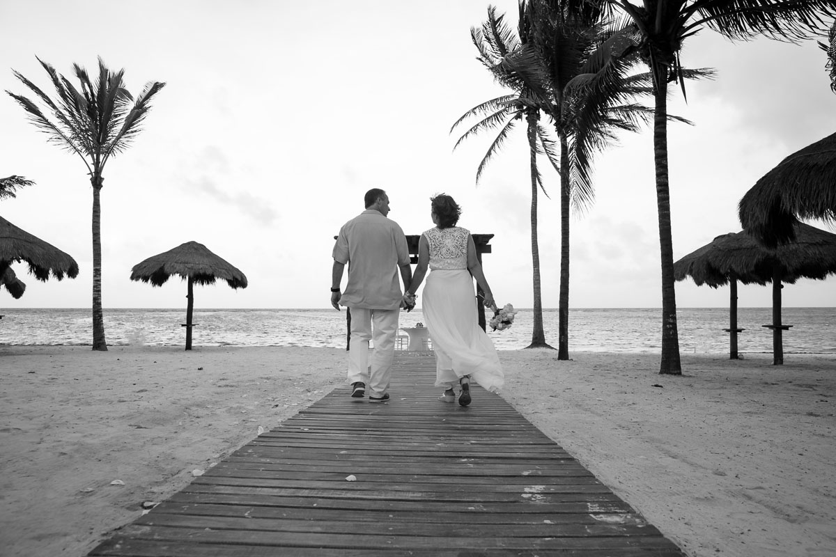 AnniversaryCoupleWalkingToBeachsideTable
