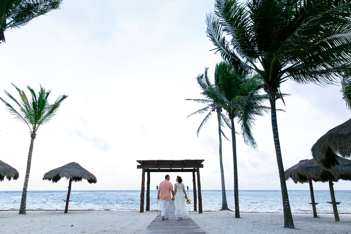 AnniversaryCoupleWalkingToBeachsideTable