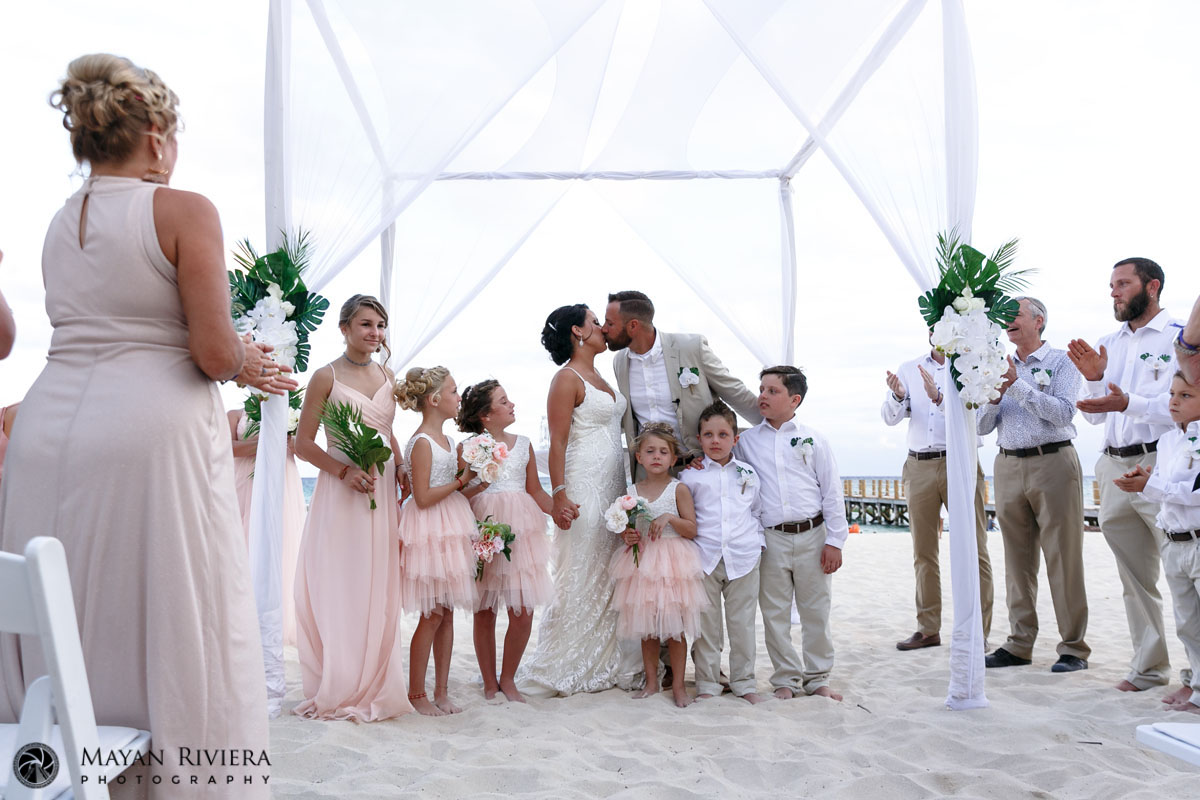 Newlyweds kiss surrounded by their newly blended family