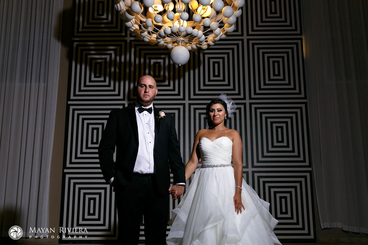 NewlywedsPoseUnderChandelier