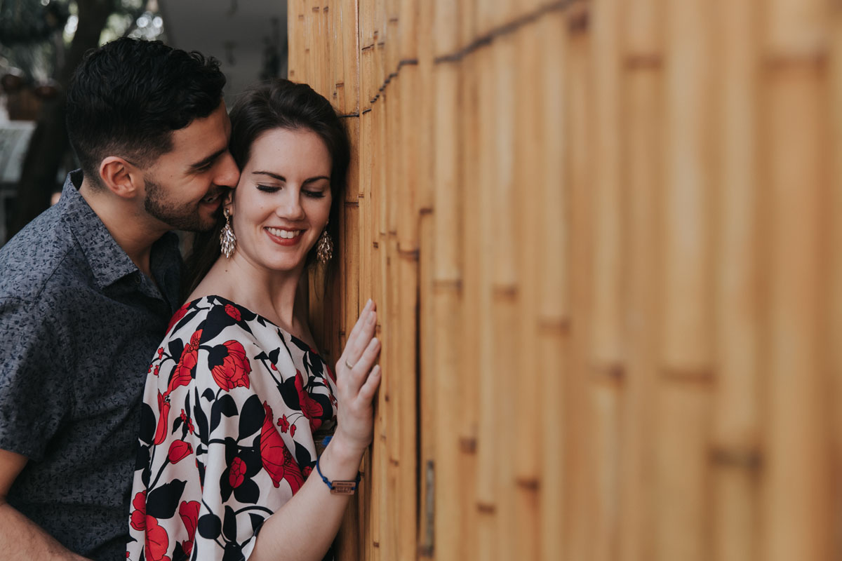 HusbandNuzzlesWifesEarByBambooWall