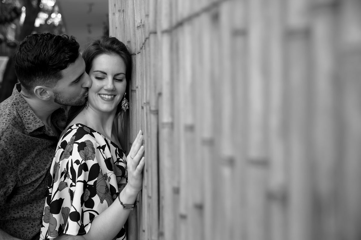 HusbandKissesWifeByBambooWall