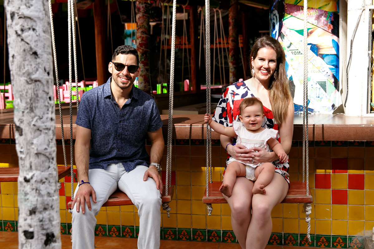 MamaHoldsLaughingBabyOnBarSwing