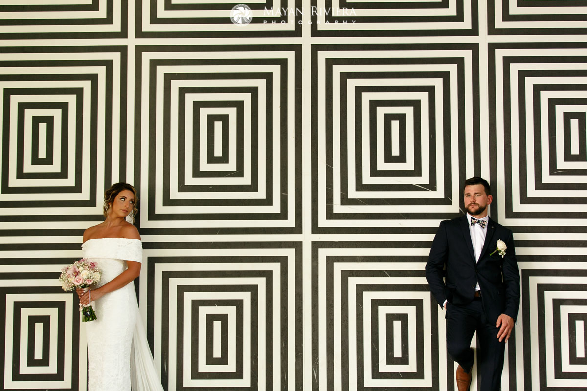 WeddingCouplePoseLeaningOnDesignWall