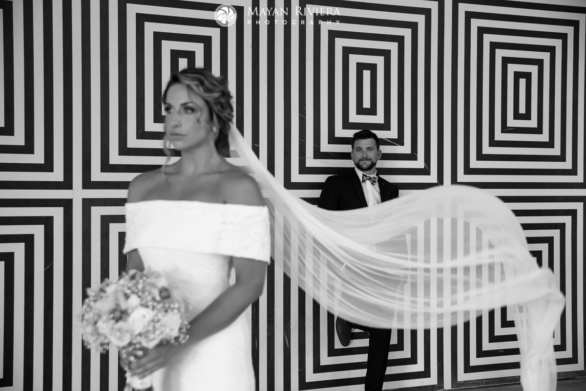 WeddingCouplePosesInFrontOfDesignWall