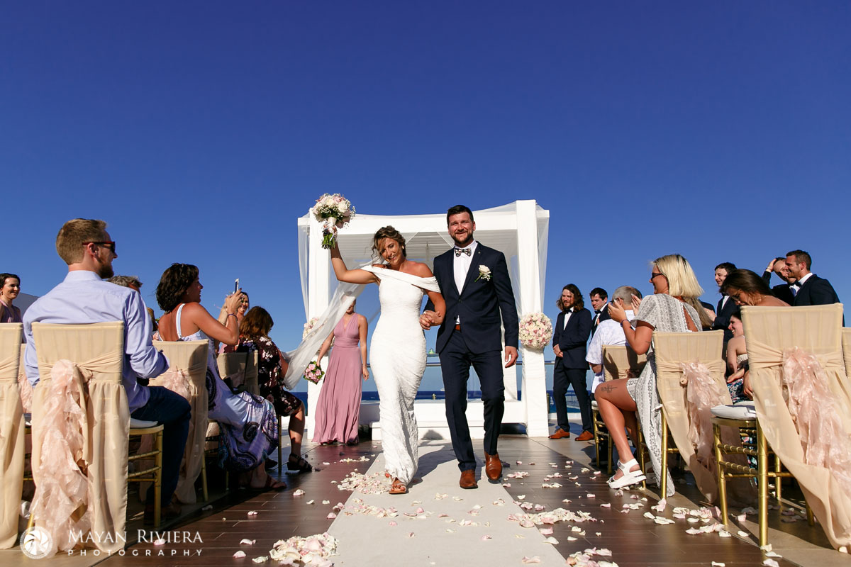 NewlywedsCheeringWalkingOutOverPetals