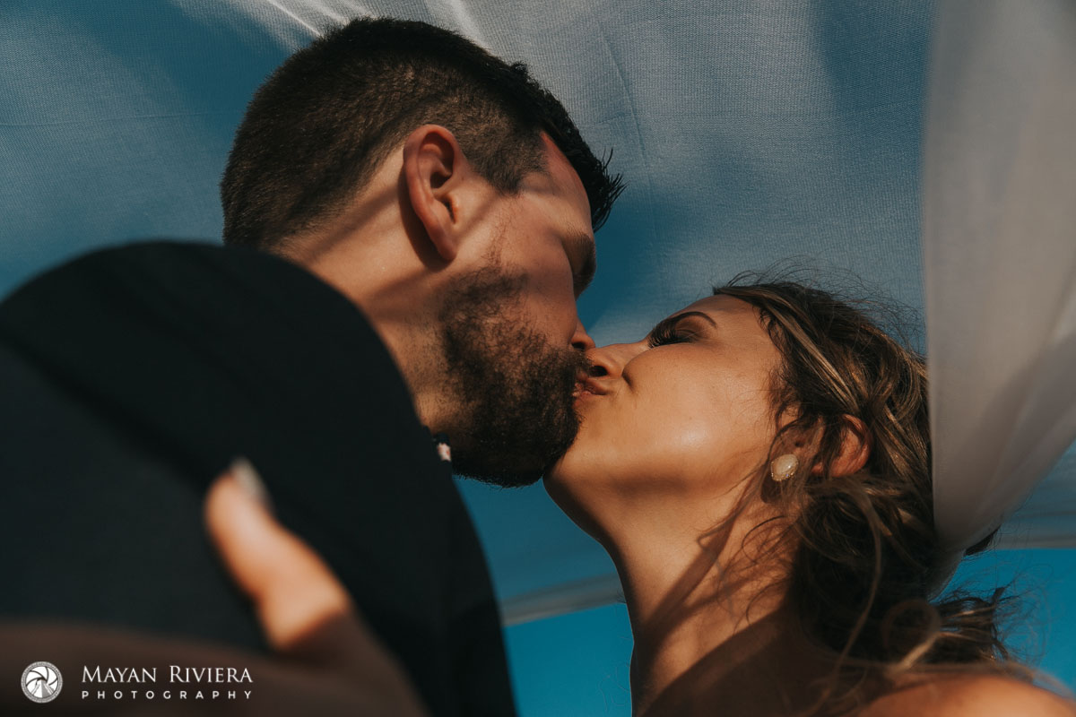 NewlywedsKissUnderBillowingVeil