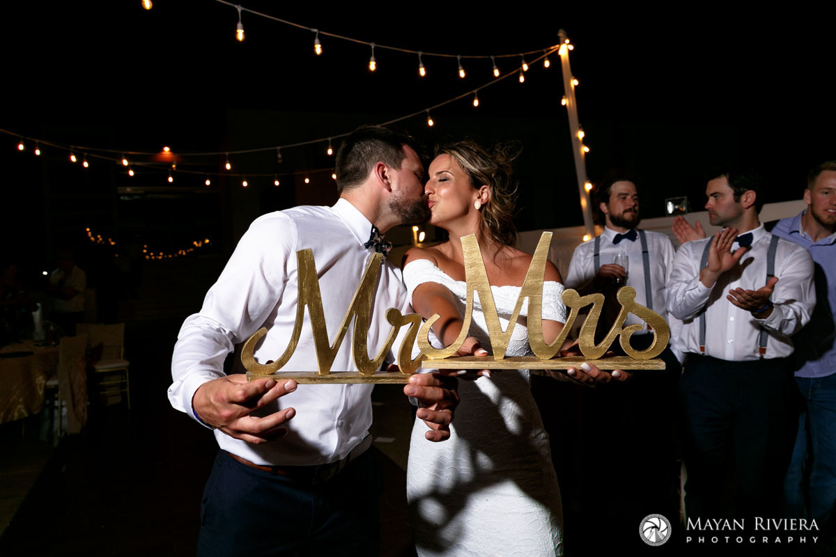 NewlywedsKissBehindMr+MrsSign