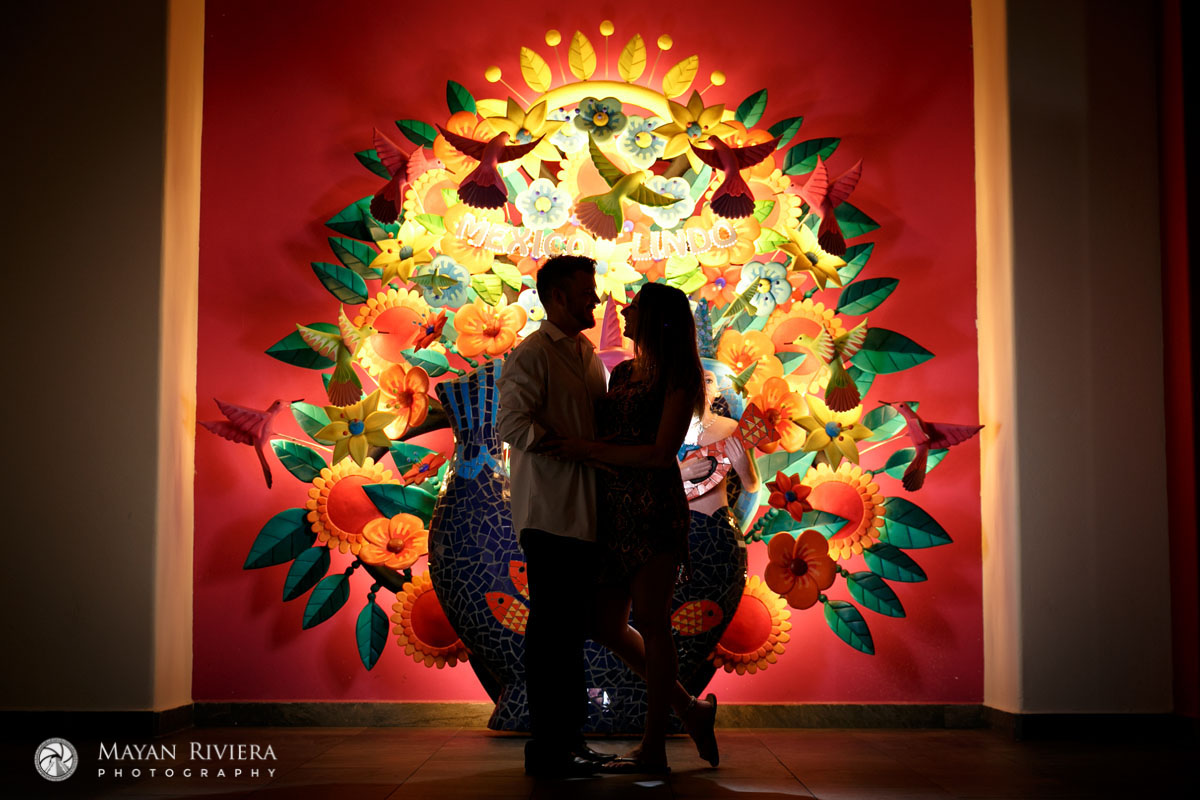 CoupleEmbraceInFrontOfLitWallArt