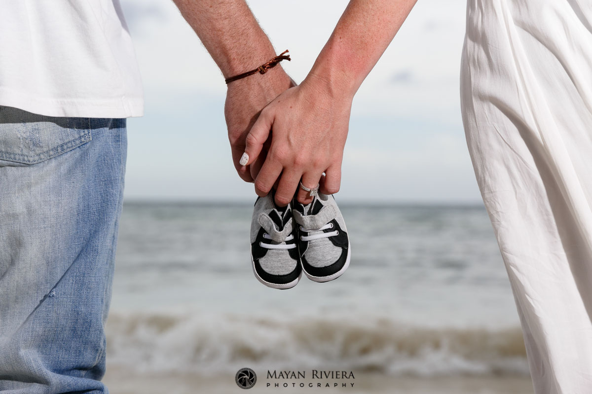 CoupleHoldsBabyShoesShowingRing