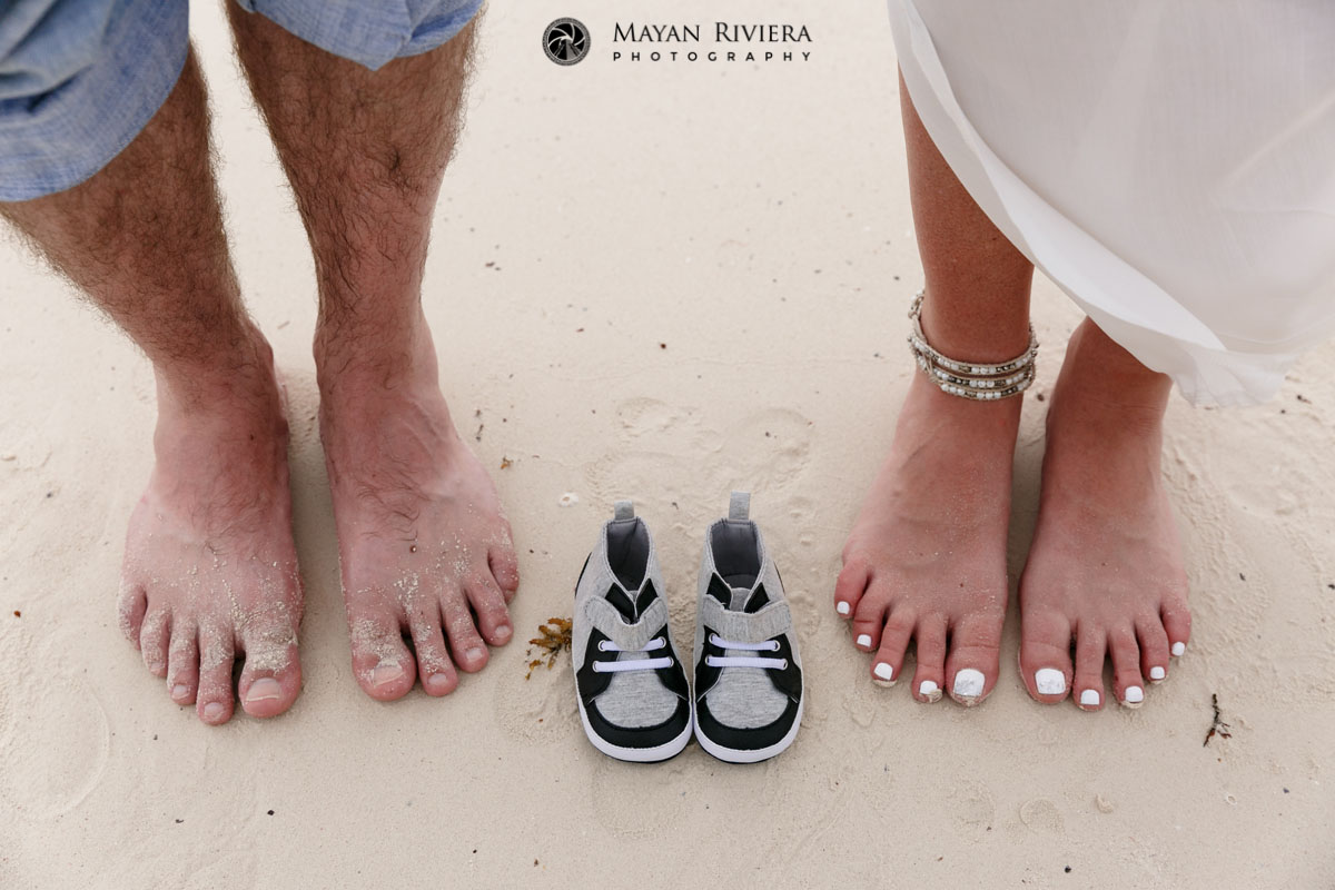 CouplePosesBarefootWithBabyShoesOnBeach