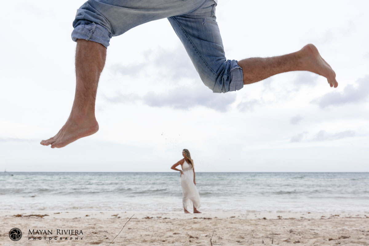 CaitlinFramedByJasonsLegsJumpingOnBeach