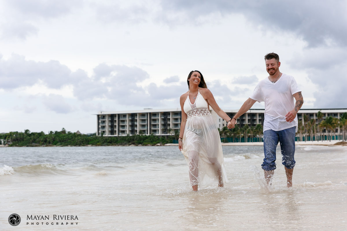 CoupleSplashesHandInHandOnBeach