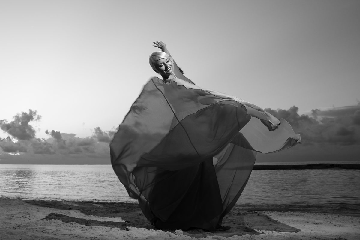 GitaTwirlsHerDressOnBeachtAtSunrise