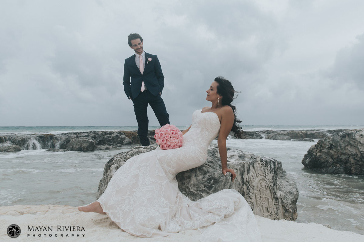 GroomWatchesBrideSittingOnRock