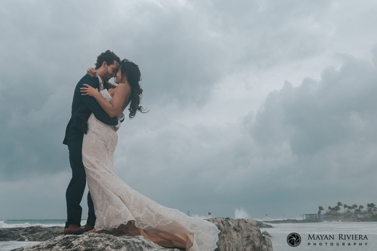 GroomHoldsBrideStandingOnRock