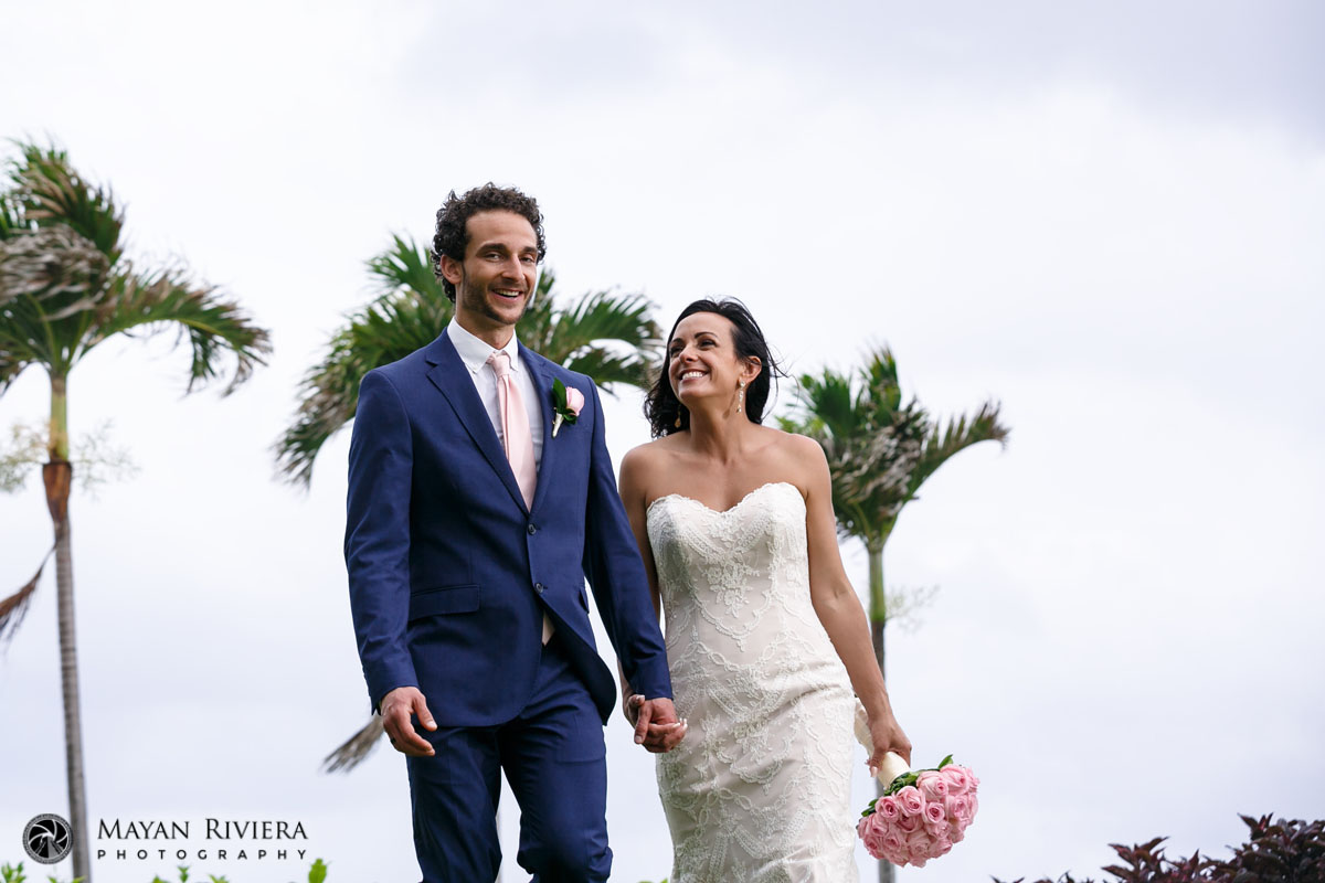 NewlywedsStrollLawnHoldingHands