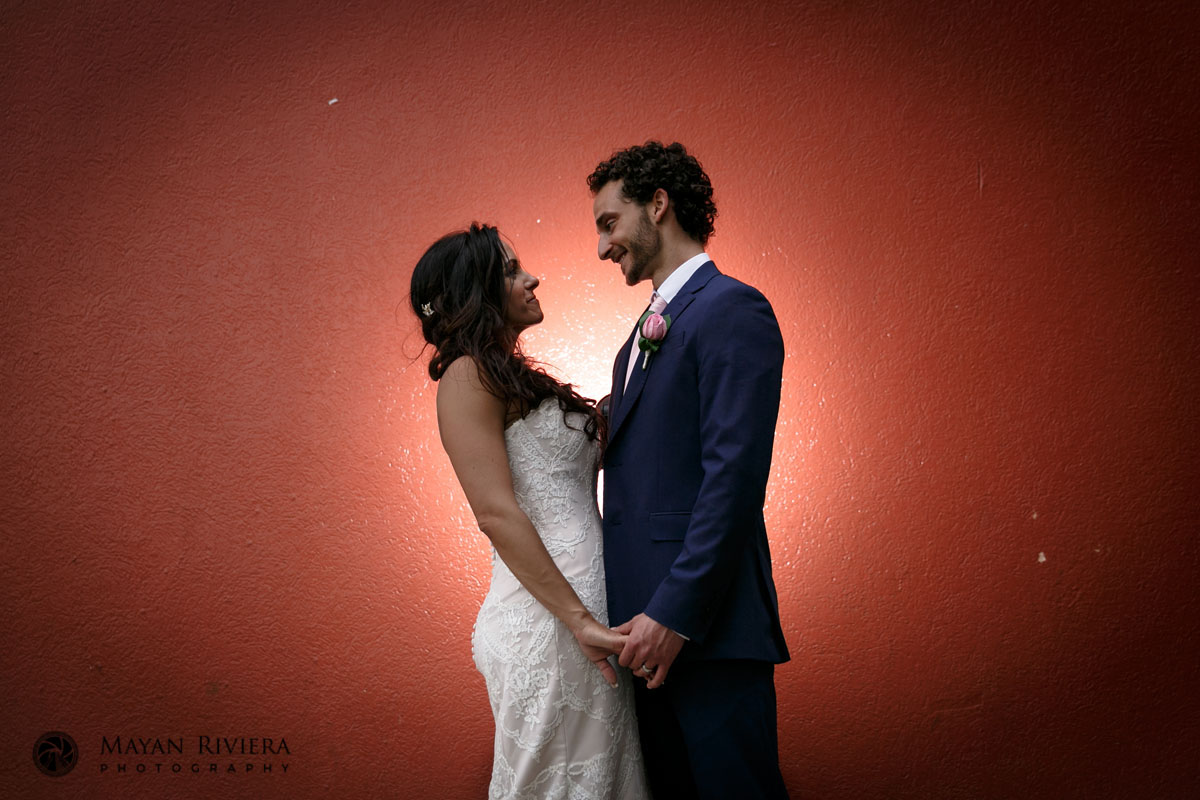 NewlywedsPoseByRedWall