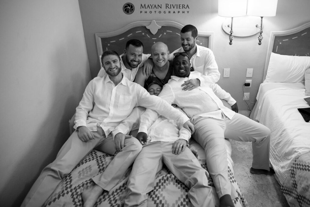 GroomWithGroomsmenOnBed