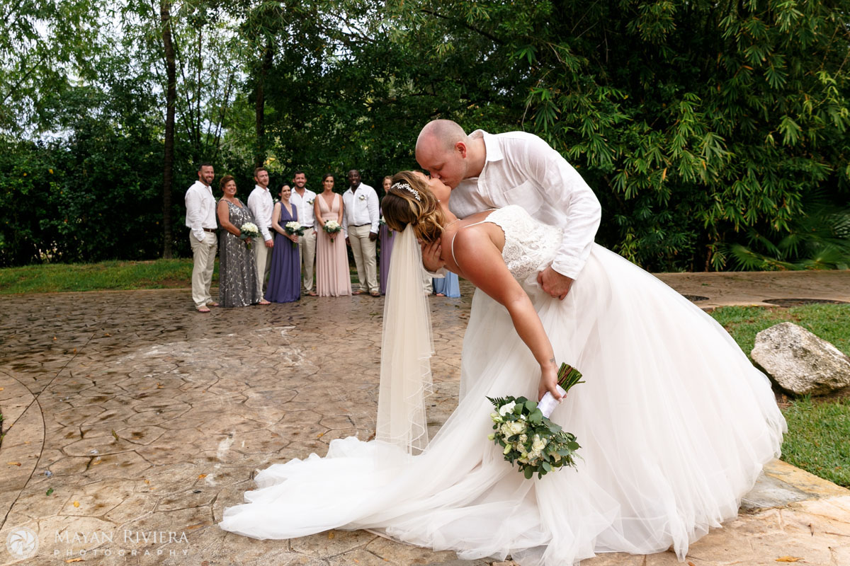 Newlyweds dip in a kiss in front of their entourage