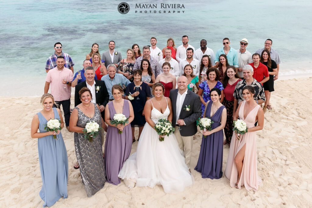 WeddingGuestsWithNewlywedsInBeachDroneShot