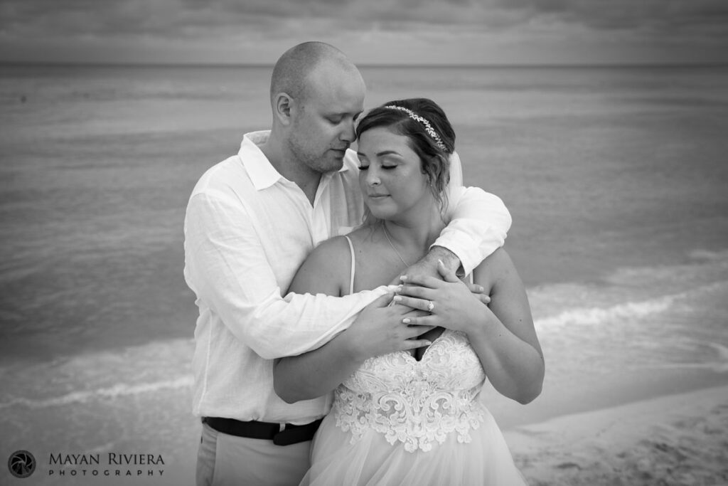 NewlywedsEmbraceOnBeach