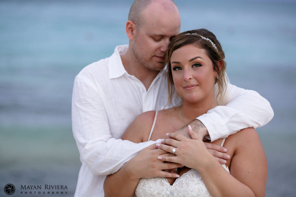 NewlywedsEmbraceOnBeach