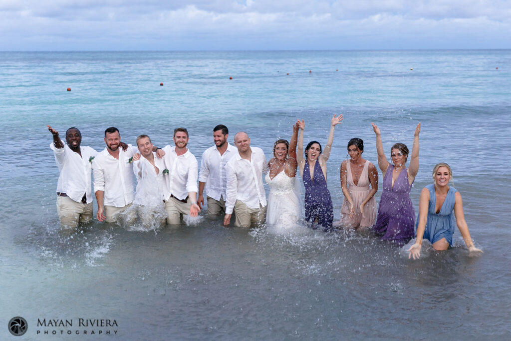 WeddingPartySplashesWaterStandingInOcean