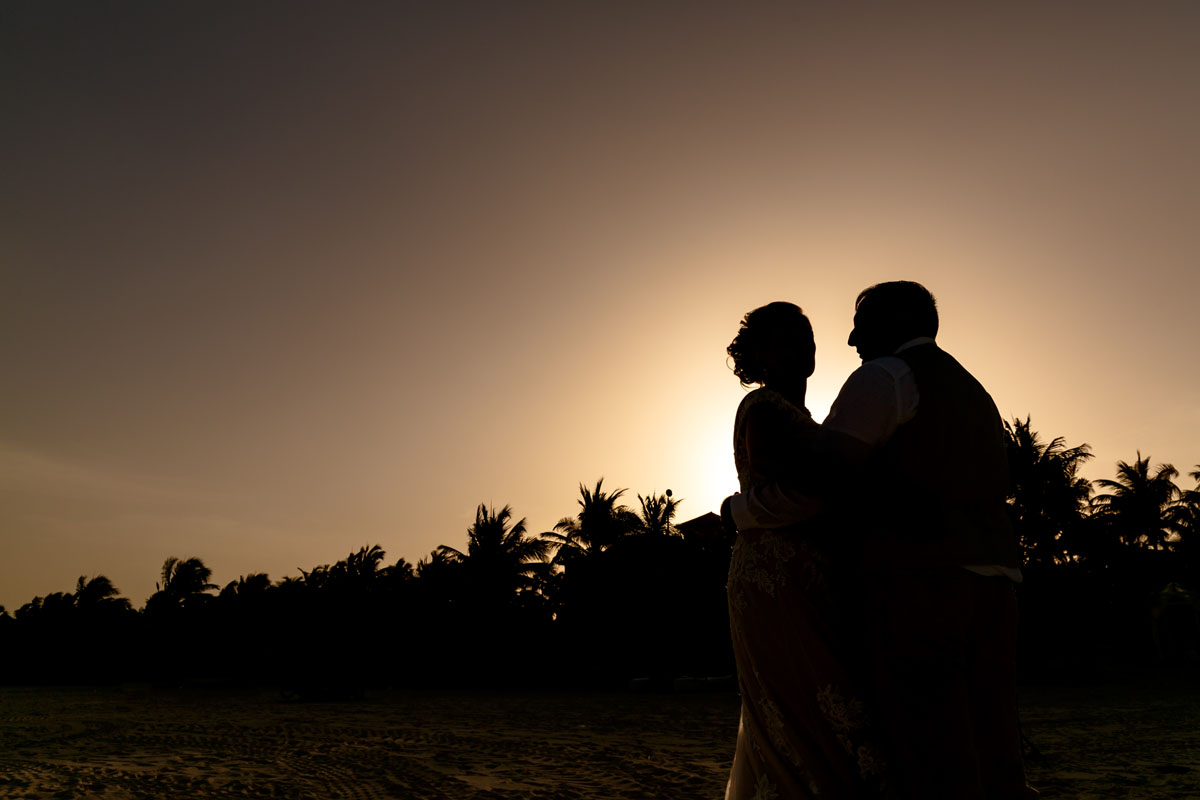 NewlywedsPoseOnBeachInSunsetShilouette