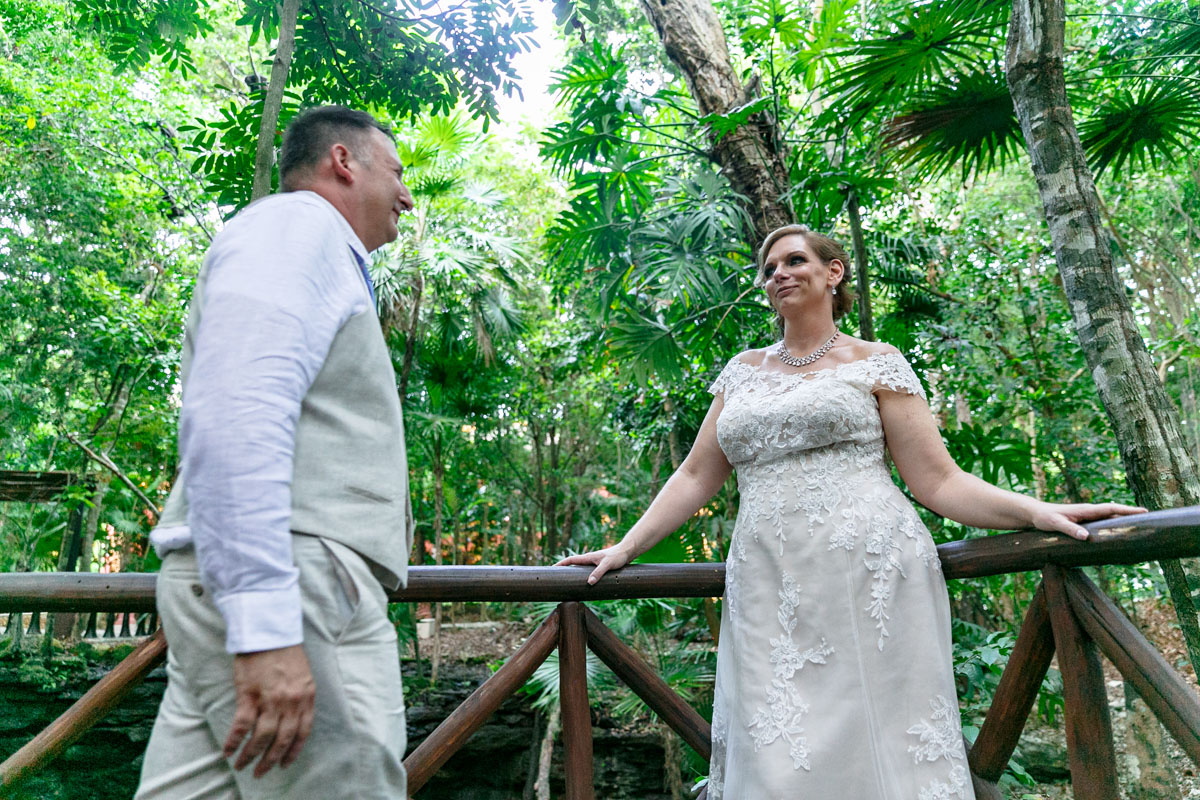 NewlywedsSmileAtEachOtherOnJungleBridge