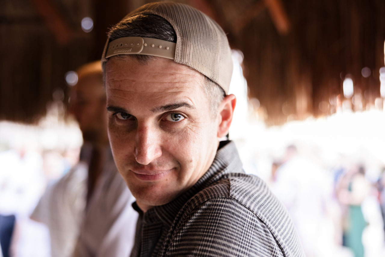 Smiling man in baseball cap looks over his shoulder