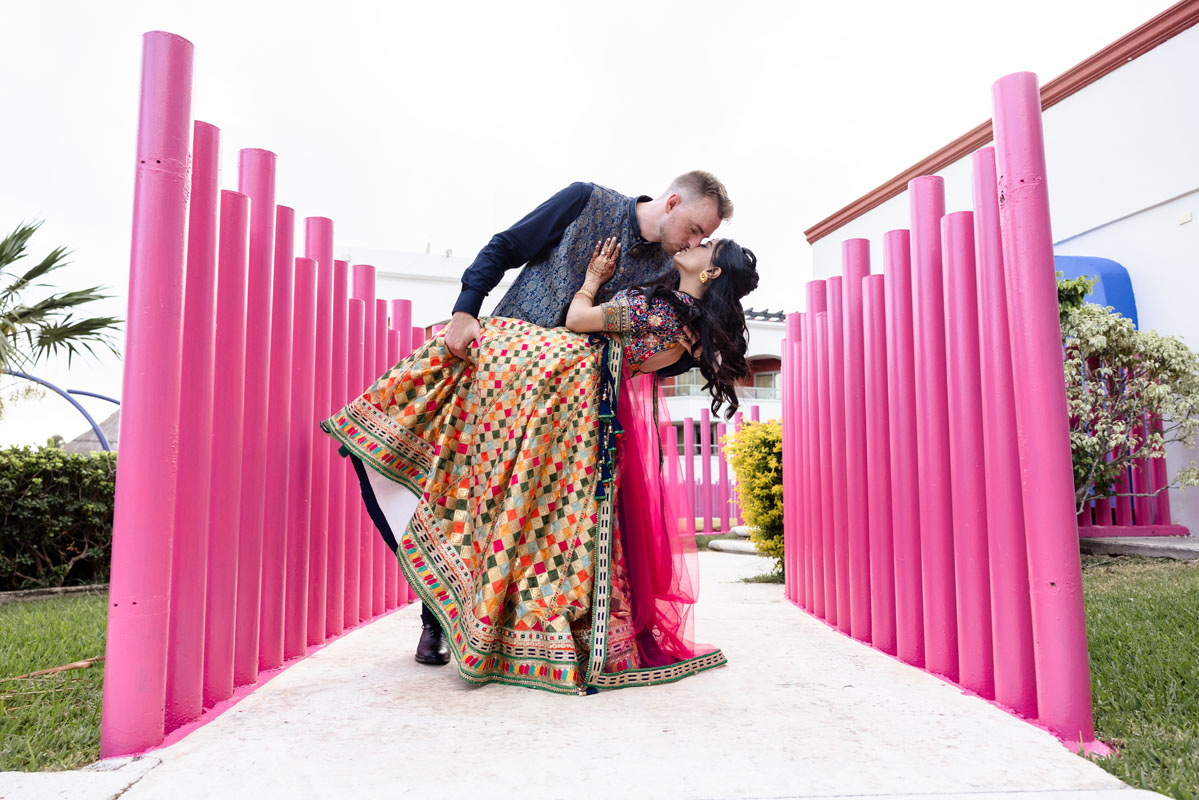 Indian groom dips his bride in a kiss