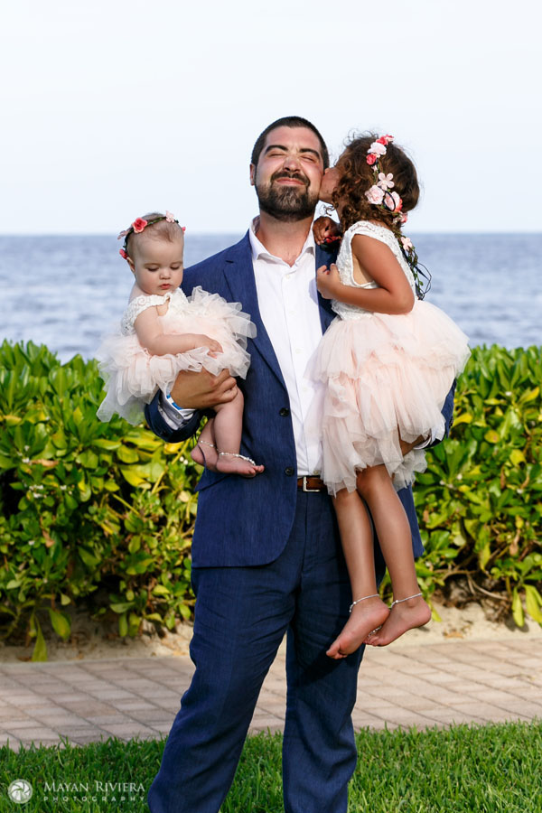 GroomDadHoldsKissingDaughters