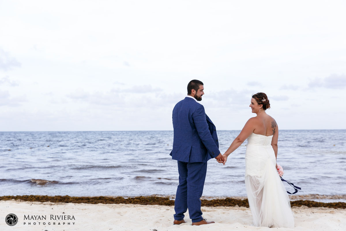 SmilingNewlywedsHoldHandsOnBeach