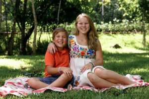 SaraSmilingWithLittleBrotherSittingOnGrass