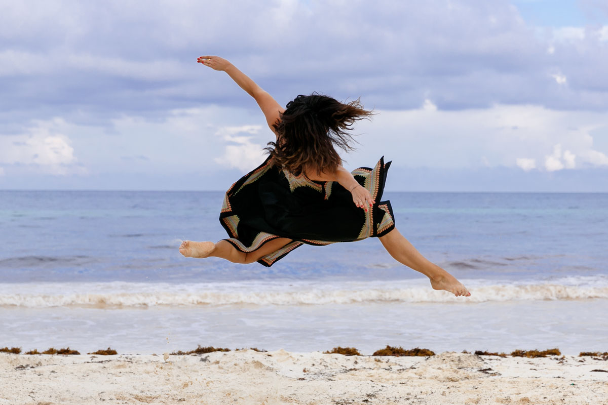 JumpingGirlTwirlsOnBeach