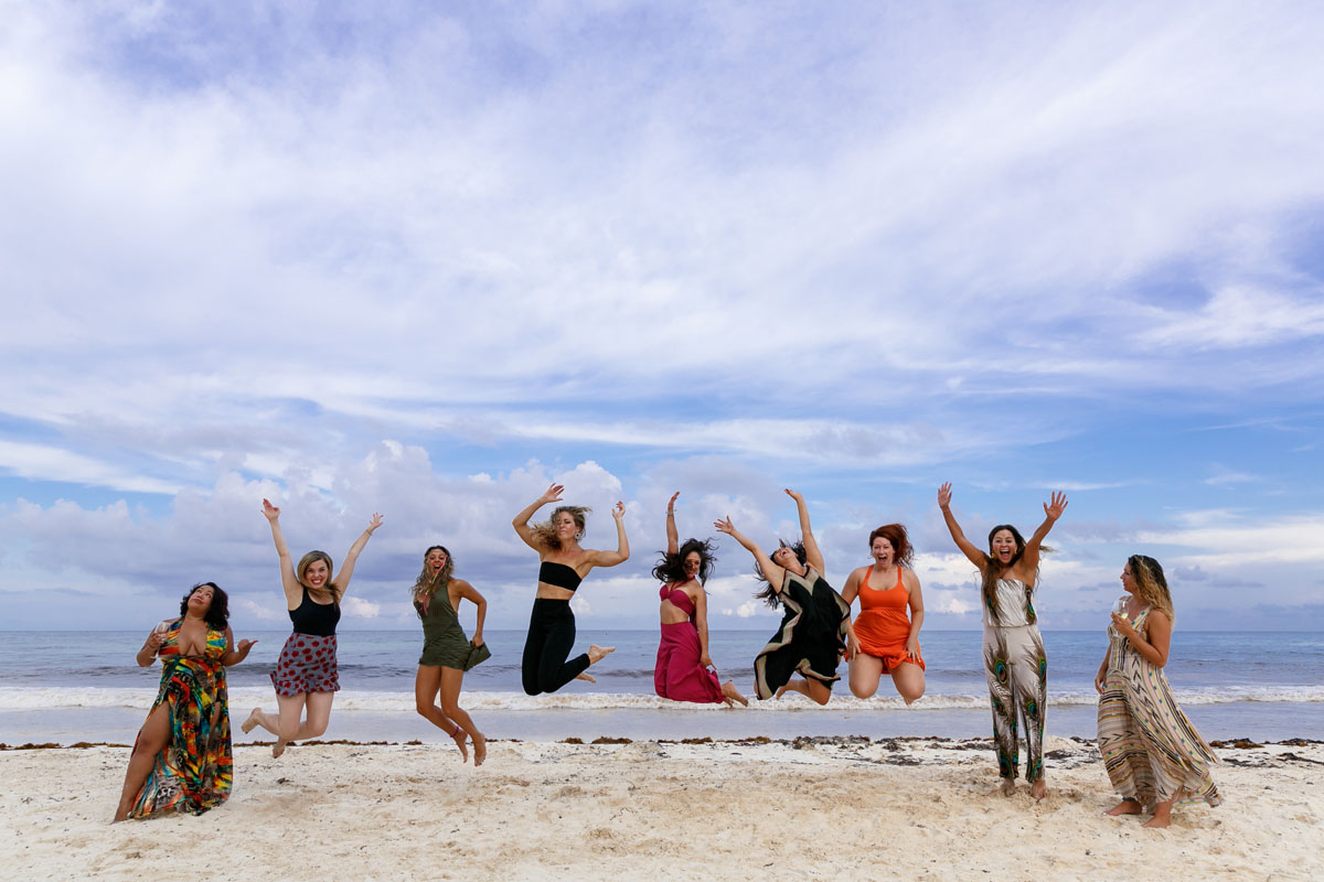 GirlsJumpForJoyOnBeachCloseUp