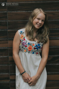 SmilingSaraLeansOnWall