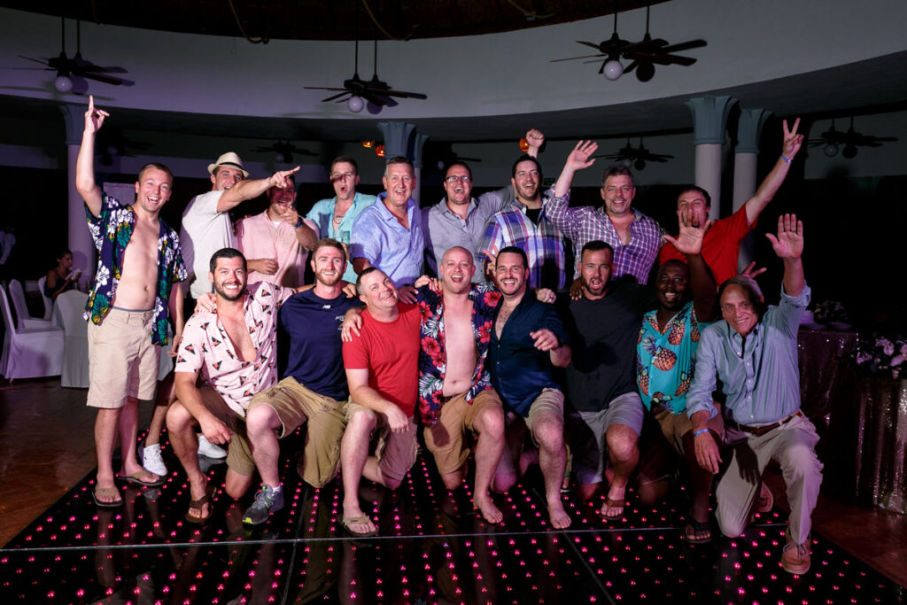 GroomKneelsWithGuysCheering