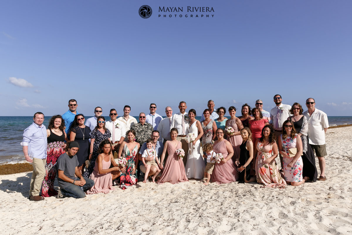 WeddingGuestsPoseOnBeachWithNewlyweds