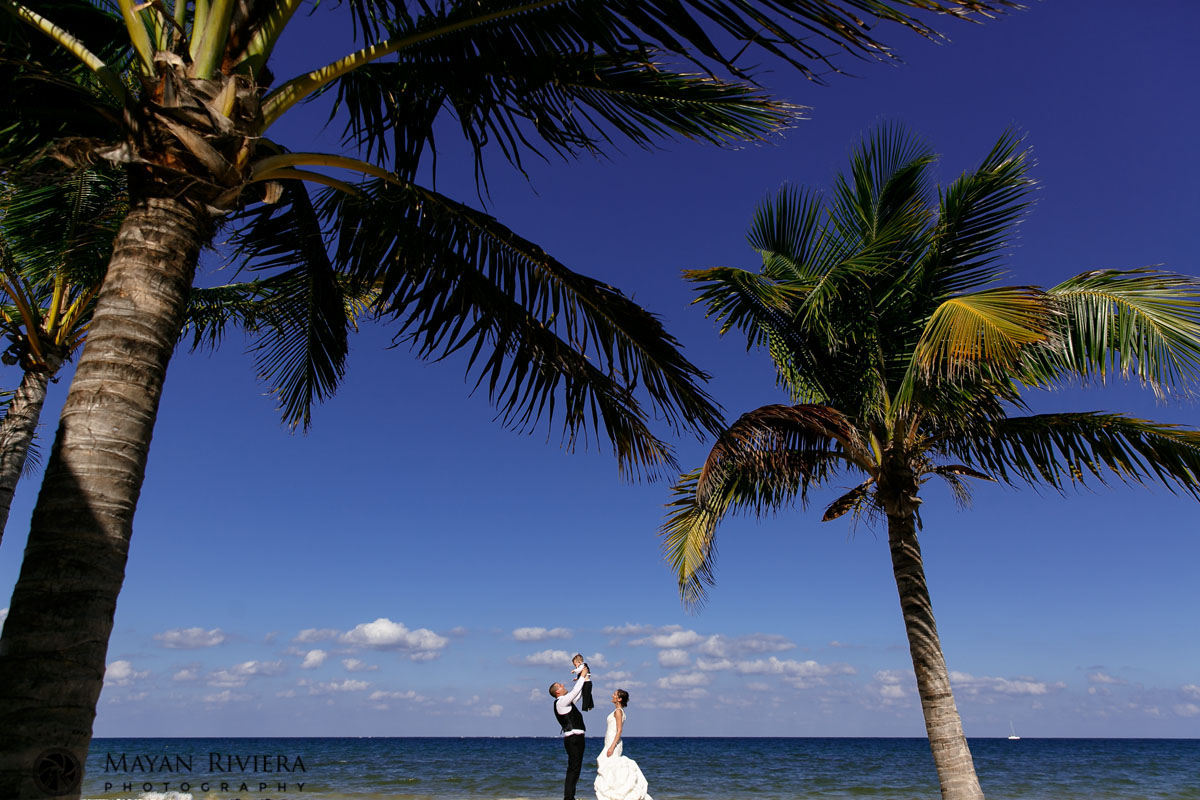 NewlywedsPoseOnBeachTossingSonInAir